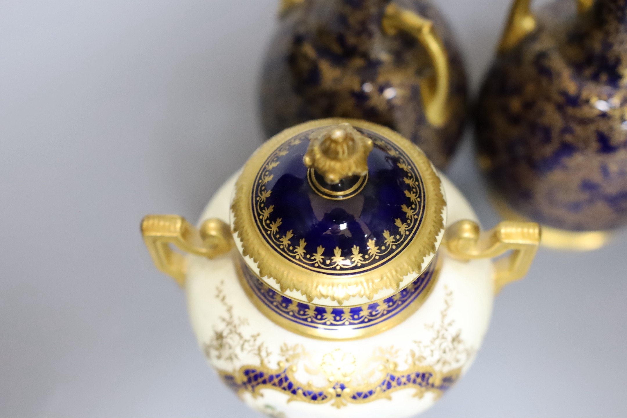 A pair of Royal Worcester bottle vases and a Coalport landscape vignette vase and cover, pair of vases 20 cms high